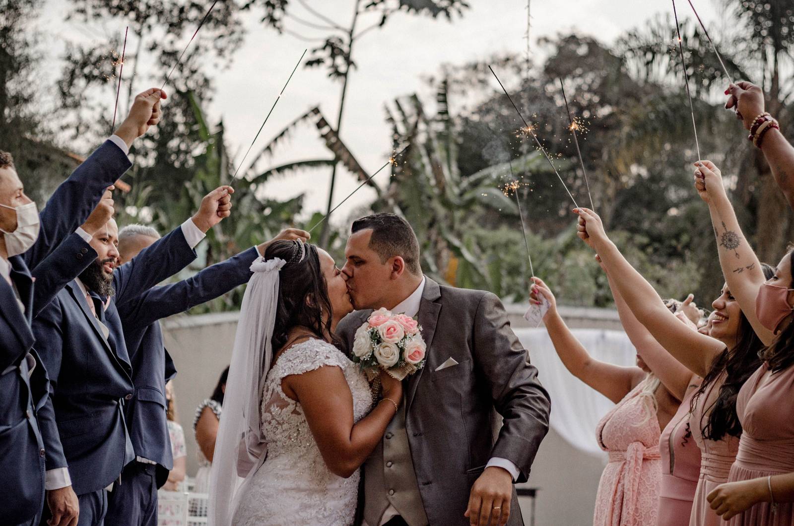 Wedding party celebrating with sparklers at dusk