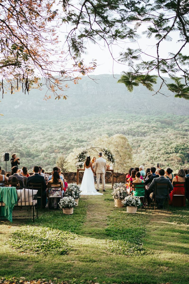 Hillside ceremony with a floral arch overlooking the valley