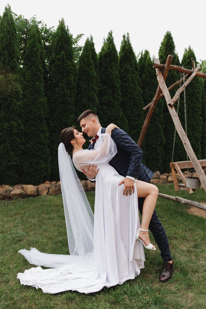 Couple sharing a kiss in a garden at golden hour